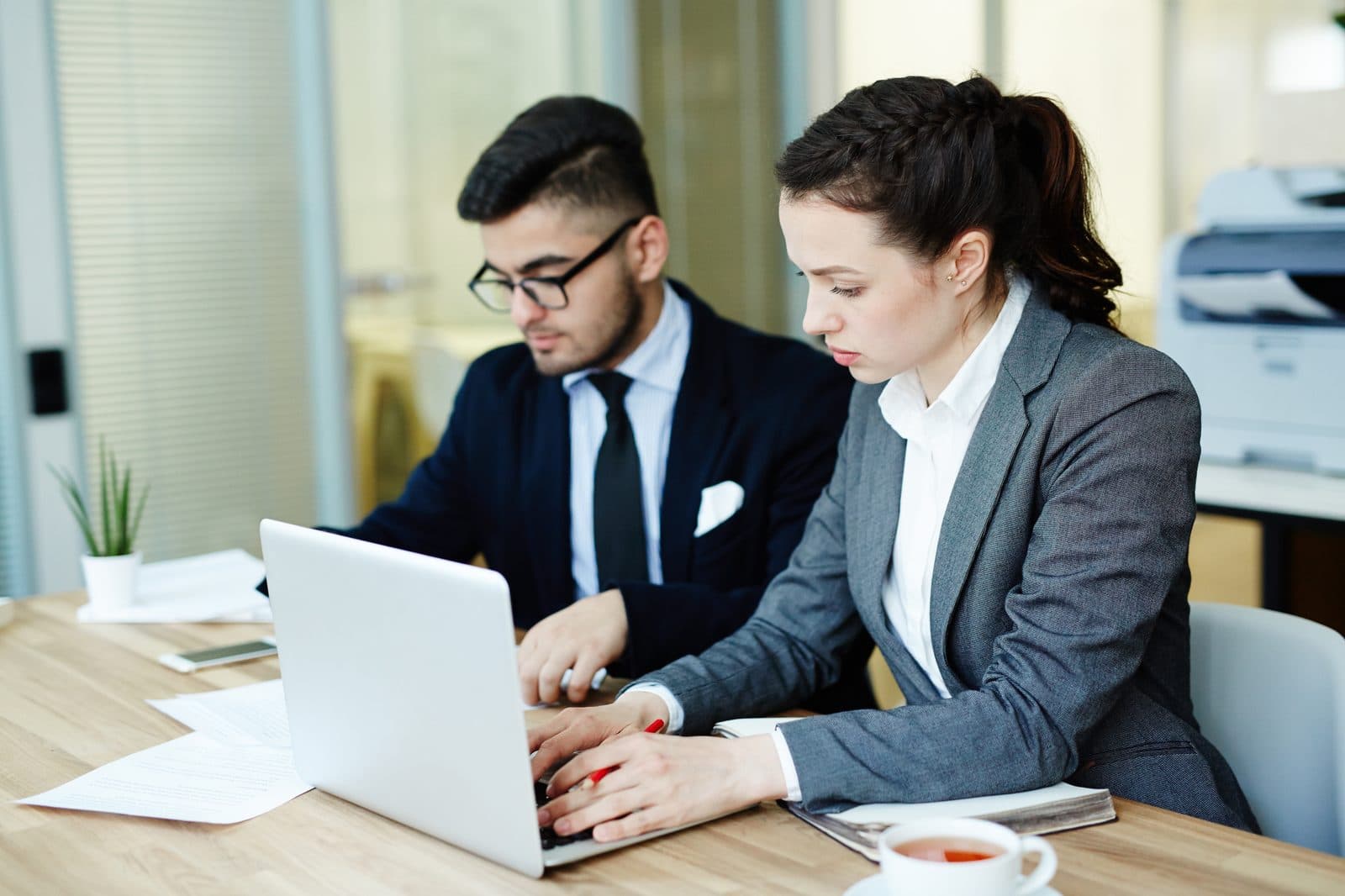 Two colleagues reviewing financial figures together on a laptop